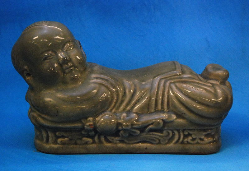 A CHINESE CELADON FIGURE OF A RECLINING BOY, 25CM