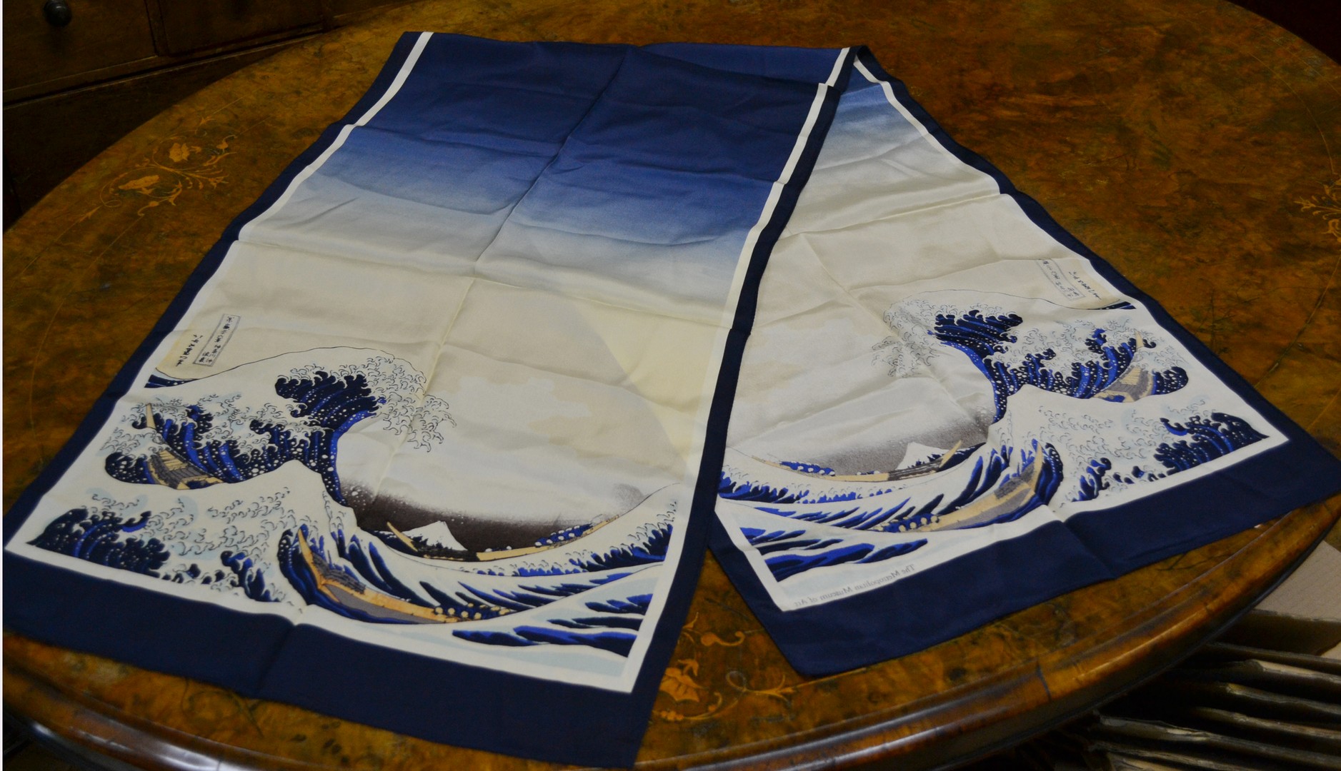 A silk scarf, decorated after Hokusai`s Great Wave, together with an oversize Zippo type lighter,