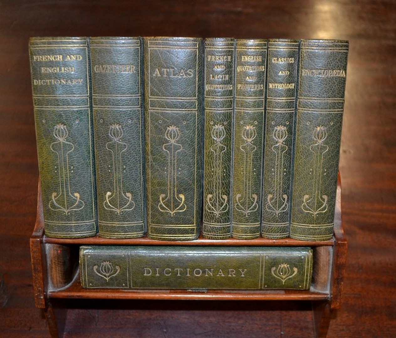 An Asprey and Co Ltd Reference Library, in a mahogany book rest holding eight leather bound books,