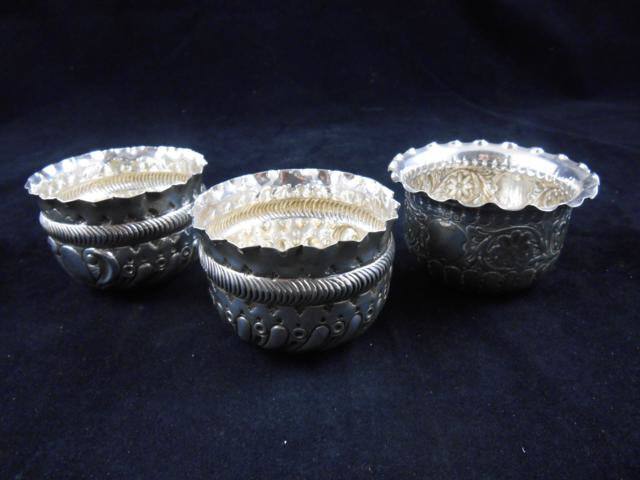 A pair of embossed white metal bowls, 7.5cm diam, together with another embossed silver bowl - total