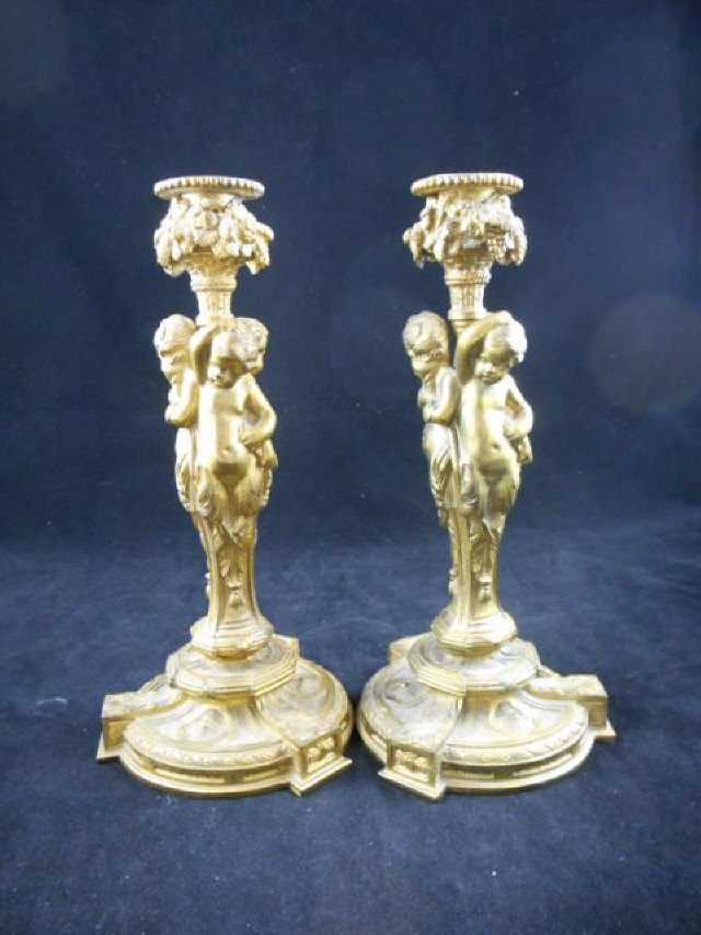 A pair of 19th century gilt brass candlesticks, cast cherub columns, acanthus leaves to base -