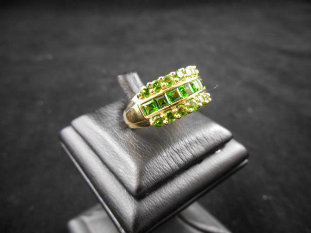 An unmarked yellow metal ring set with green stones, size O 1/2 - approx gross weight 3.9g