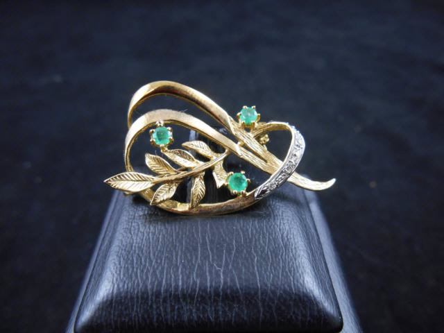 A 14ct gold spray brooch set with emeralds and diamonds - approx gross weight 4.4g