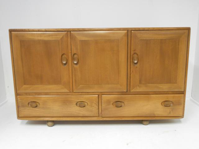 An Ercol Windsor light elm sideboard, three cupboards and two drawers below - W130cm