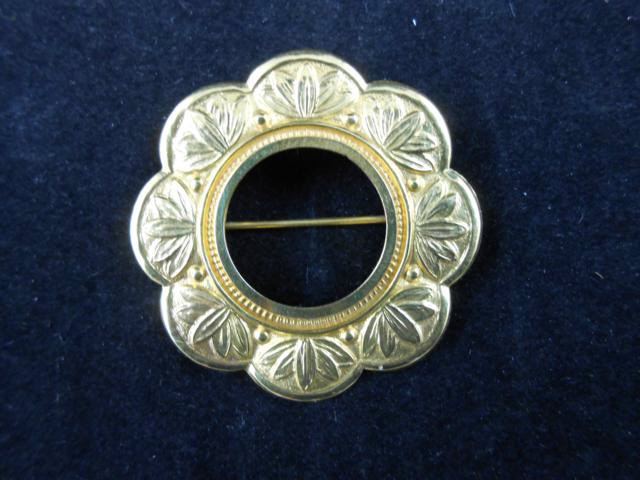 A yellow metal floral pattern brooch sovereign mount