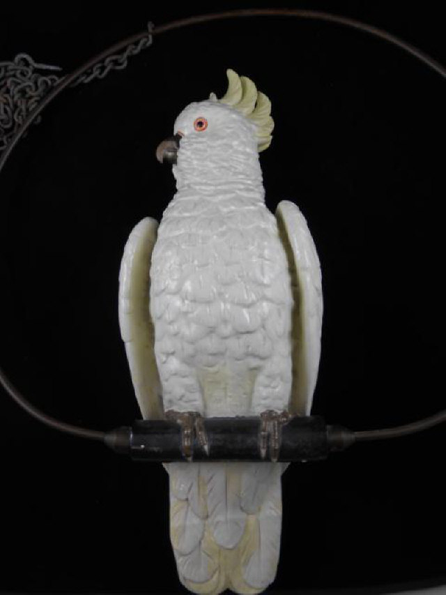 A late 19th century Dresden sulphur crested cockatoo, the bird perched within a brass hoop - H52cm