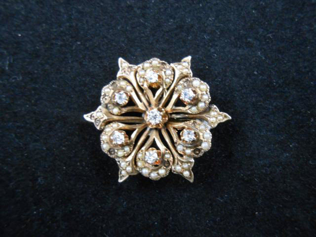 A yellow metal (tests as 9ct gold) floral design brooch mounted with seven old European cut diamonds