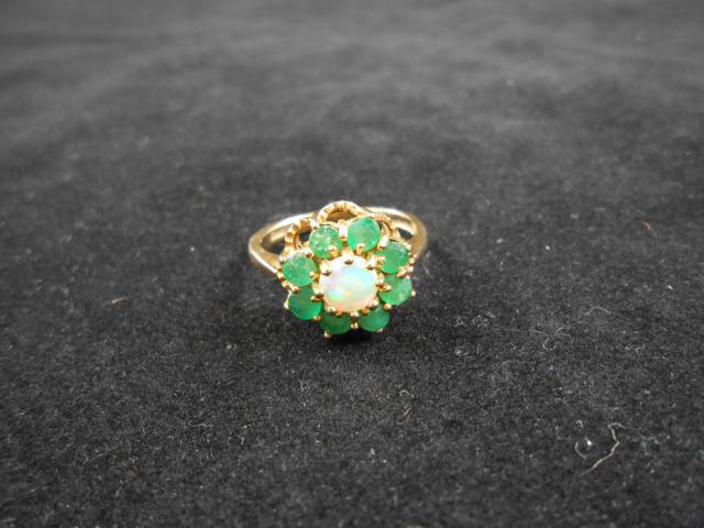 A 9ct gold ring set with centre opal surrounded by eight emeralds, size Q - approx gross weight 4.