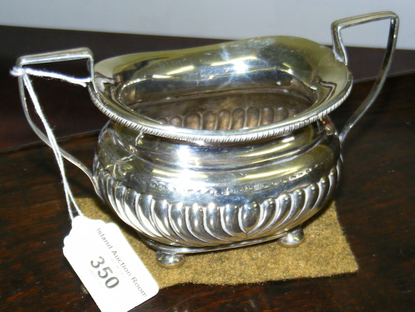 A half-fluted two-handled silver sugar bowl on bun feet