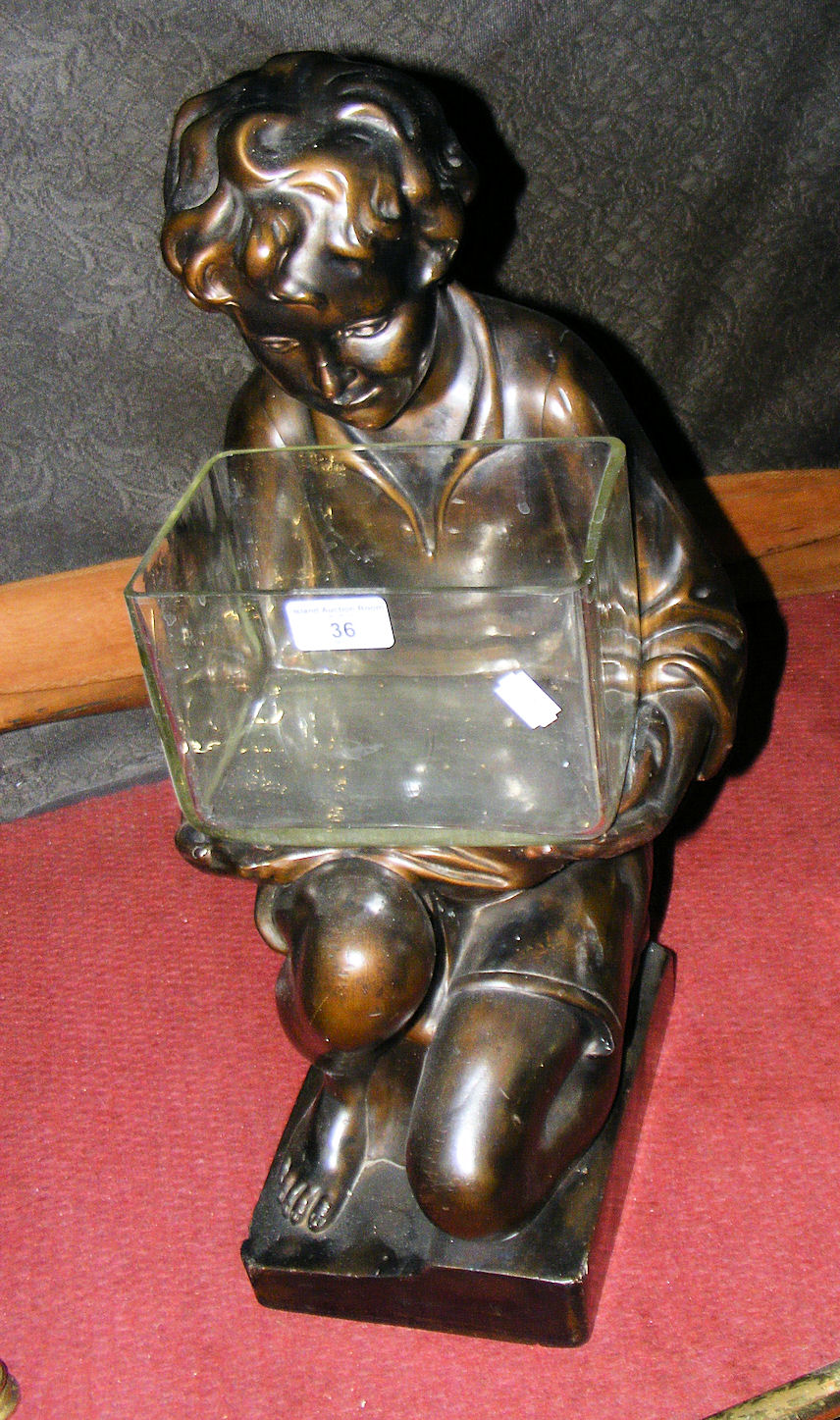 An Art Deco plaster figure of kneeling child holding glass container