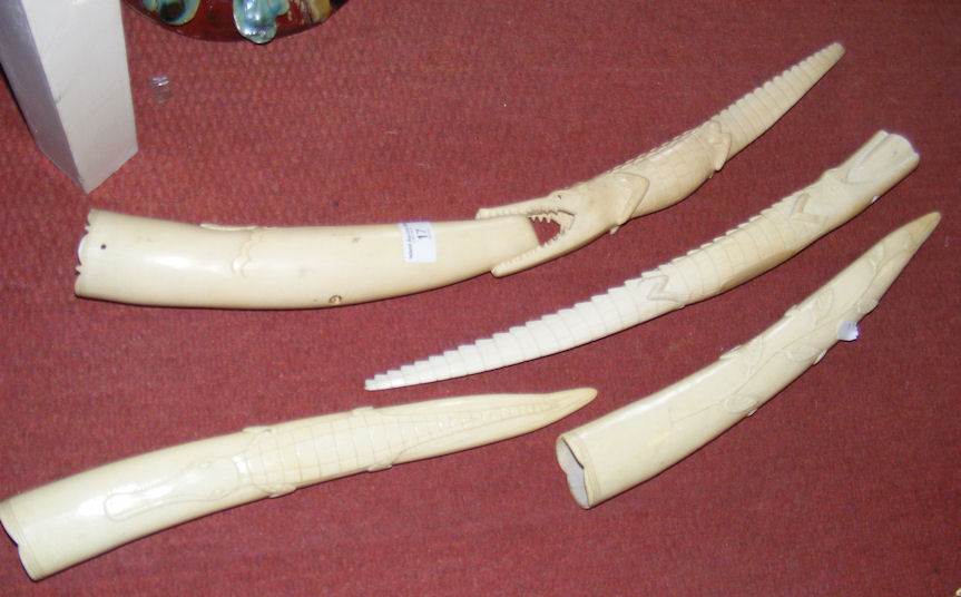 An old carved ivory tusk and three others