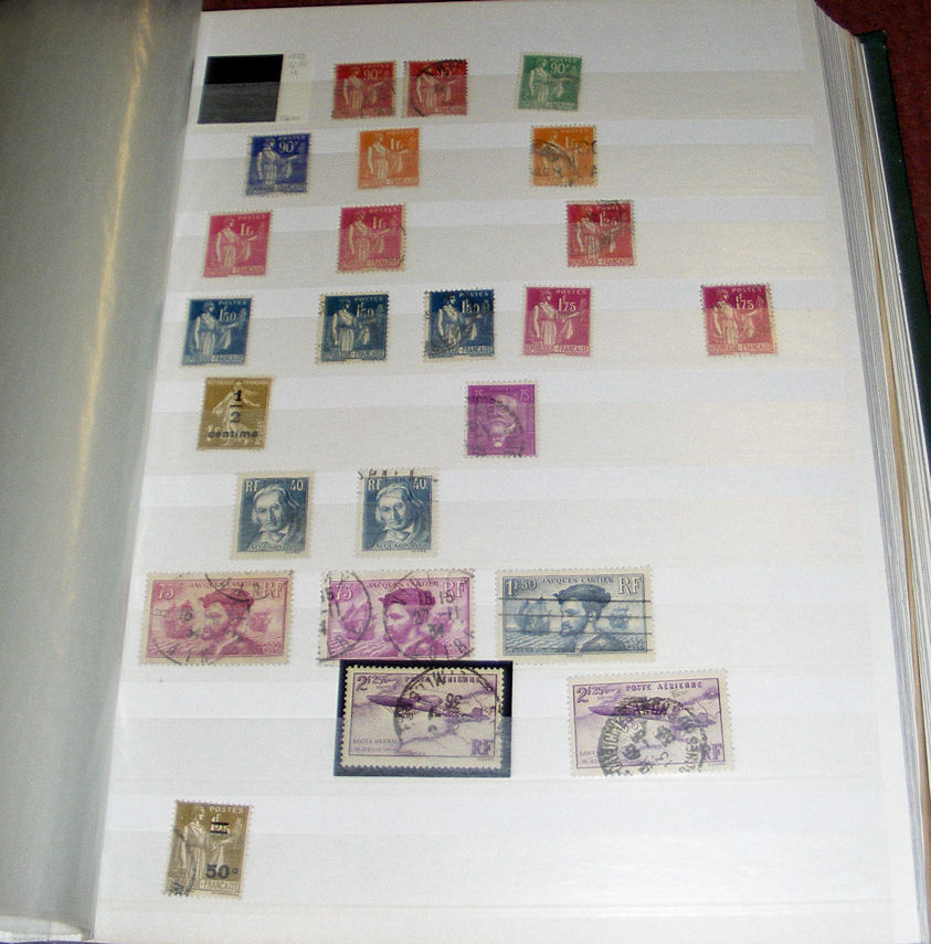 A large green stock book of French, New Zealand, GB and other world postage stamps