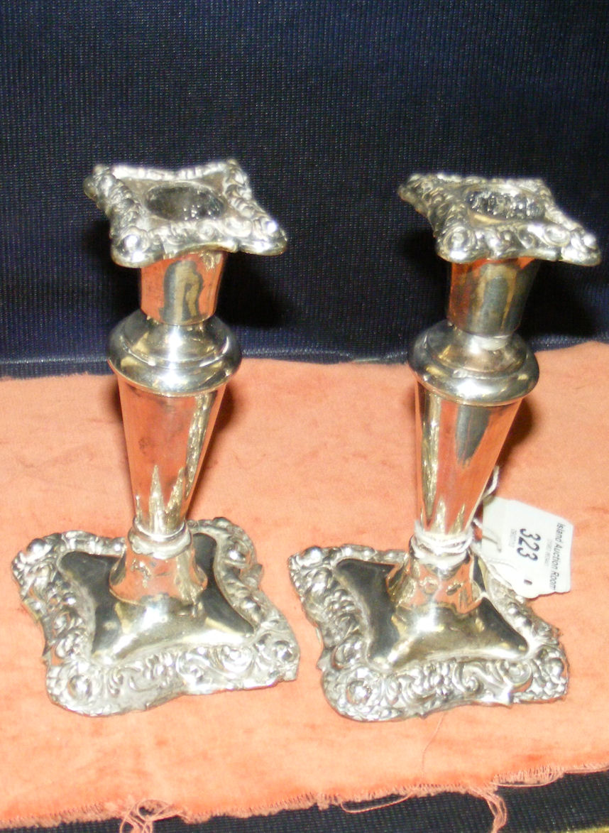 A pair of 14cm embossed weighted silver candlesticks