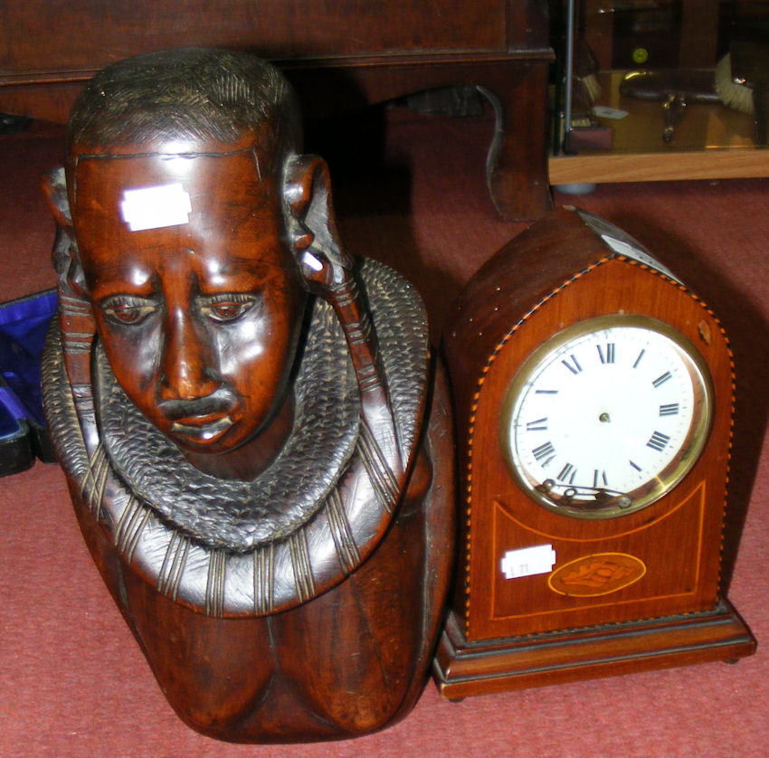 An Edwardian inlaid mahogany lancet shaped mantel clock timepiece and a carved African tribal head