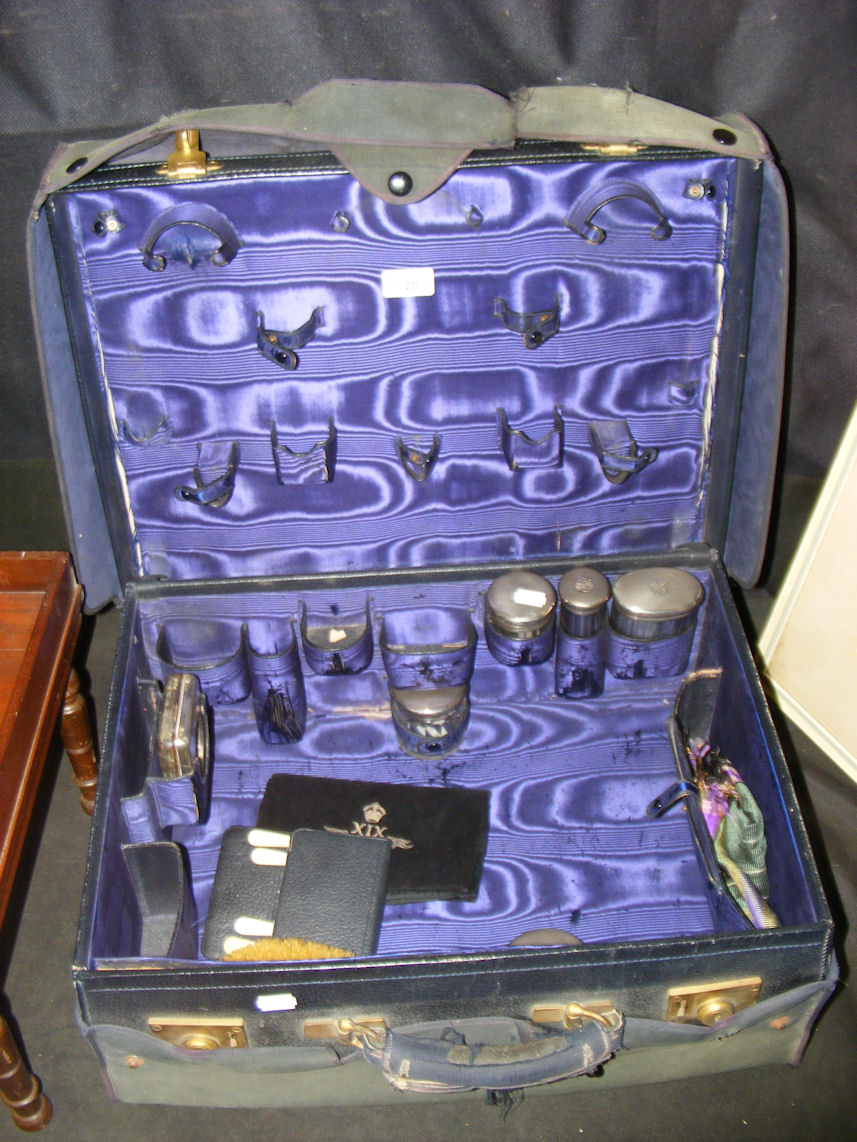 An Edwardian blue leather gentleman’s travelling vanity case with engine turned silver top bottles