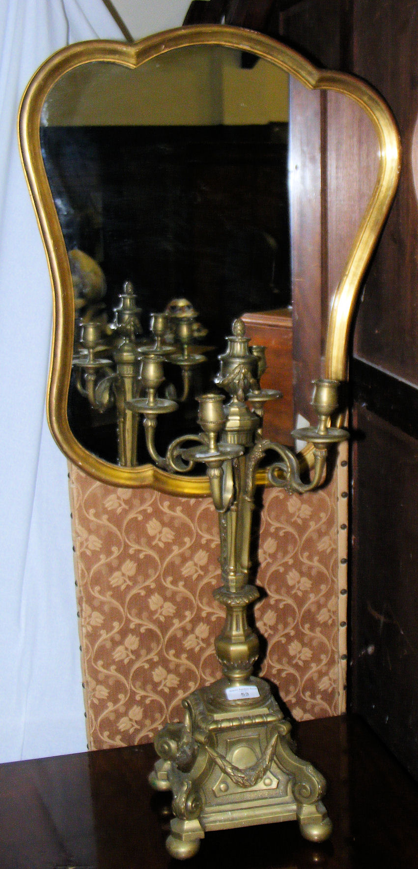 A shaped gilt wall mirror and a four branch French style candelabra