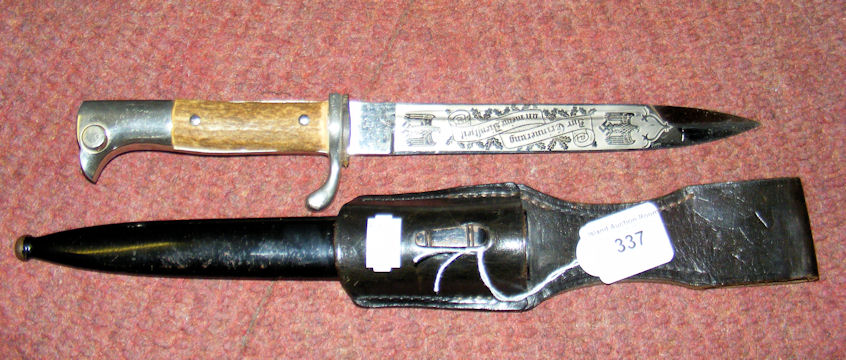 A German bayonet with engraved blade and metal scabbard