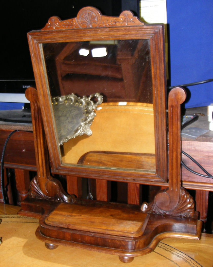 An Edwardian mahogany toilet mirror with carved and shaped surmount