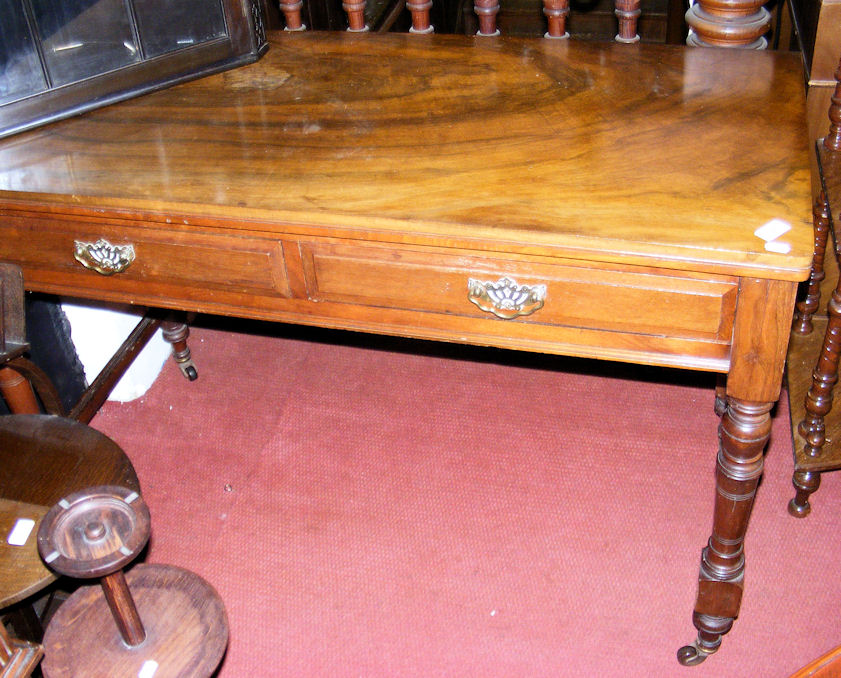 A 120cm Victorian walnut serving table with two drawers to the apron on turned supports