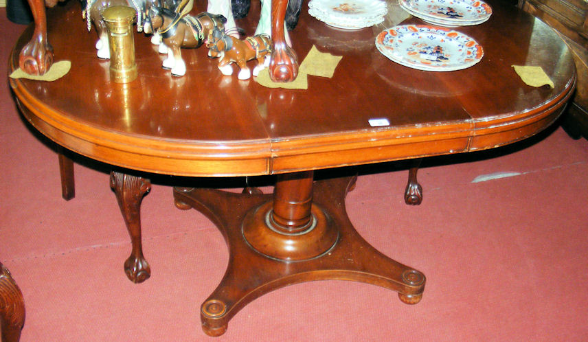 A mahogany extending dining table on pillar support