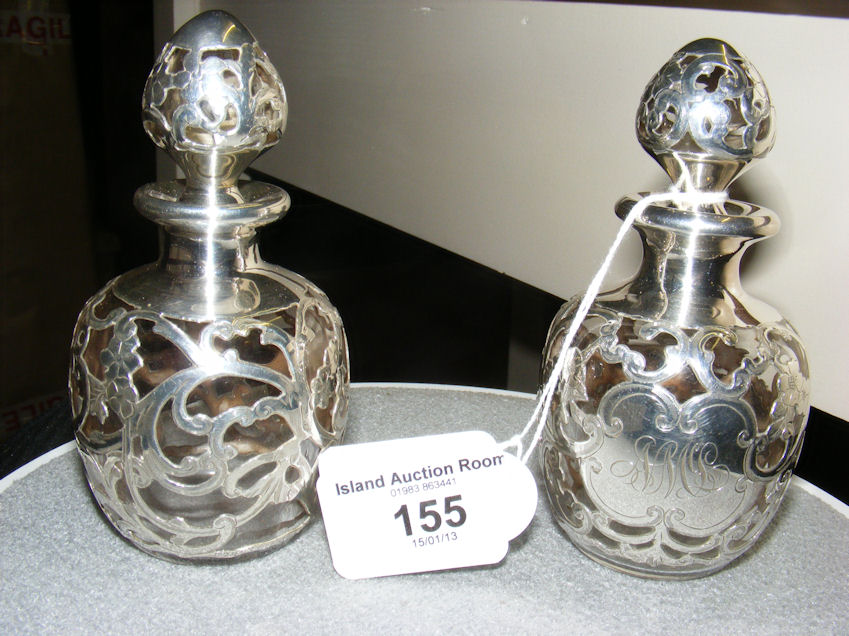 A fine pair of 11cm silver covered glass perfume bottles and stoppers