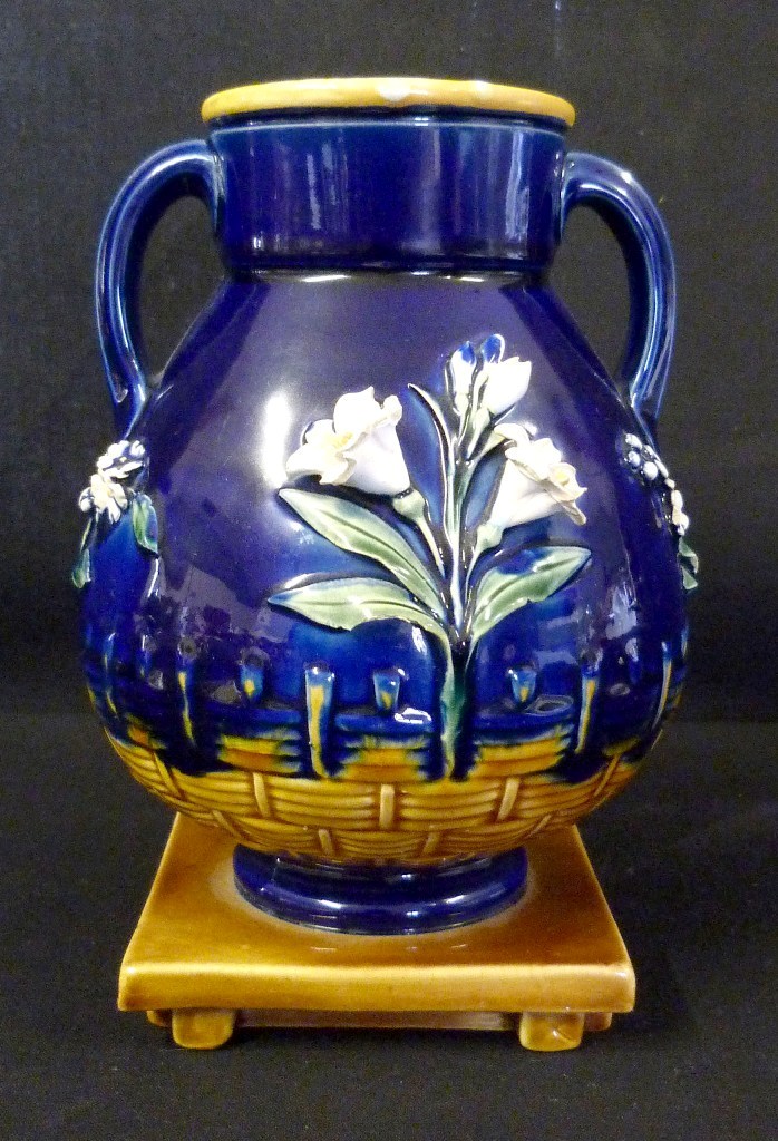 A Minton Majolica Vase, decorated in relief with a foliate design upon a dark blue ground, 17cms