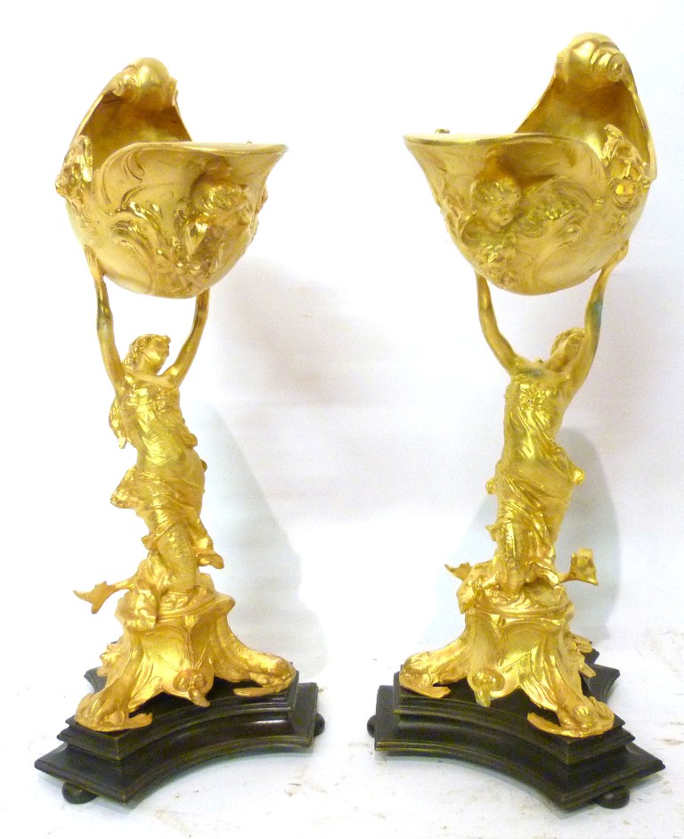 A Pair of Gilded Large Salts, in the form of conch shells, each with figural column upon a triform