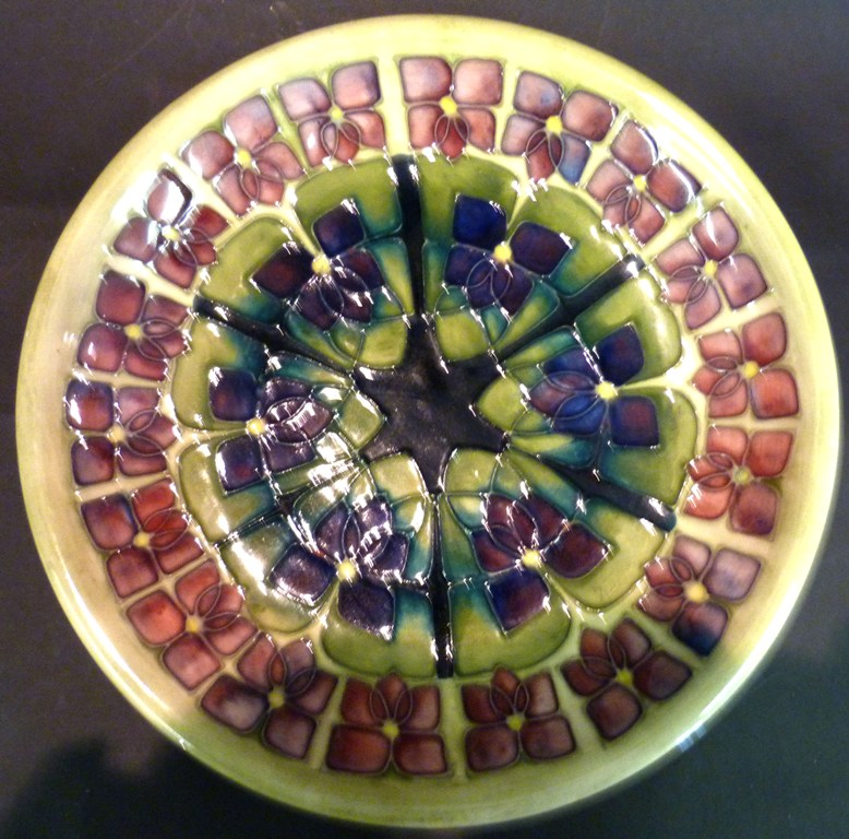 A Moorcroft Dish, tubelined with a foliate design upon a green and purple ground, 26cms diameter