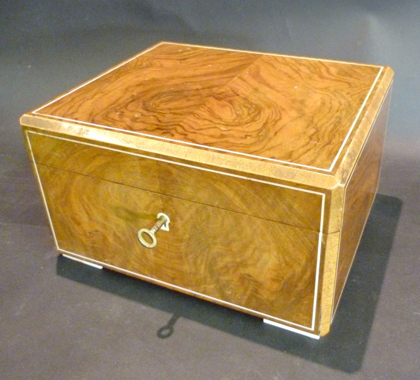 A Walnut Humidor, made by Dunhill, the hinged cover above an inlaid front, raised upon square