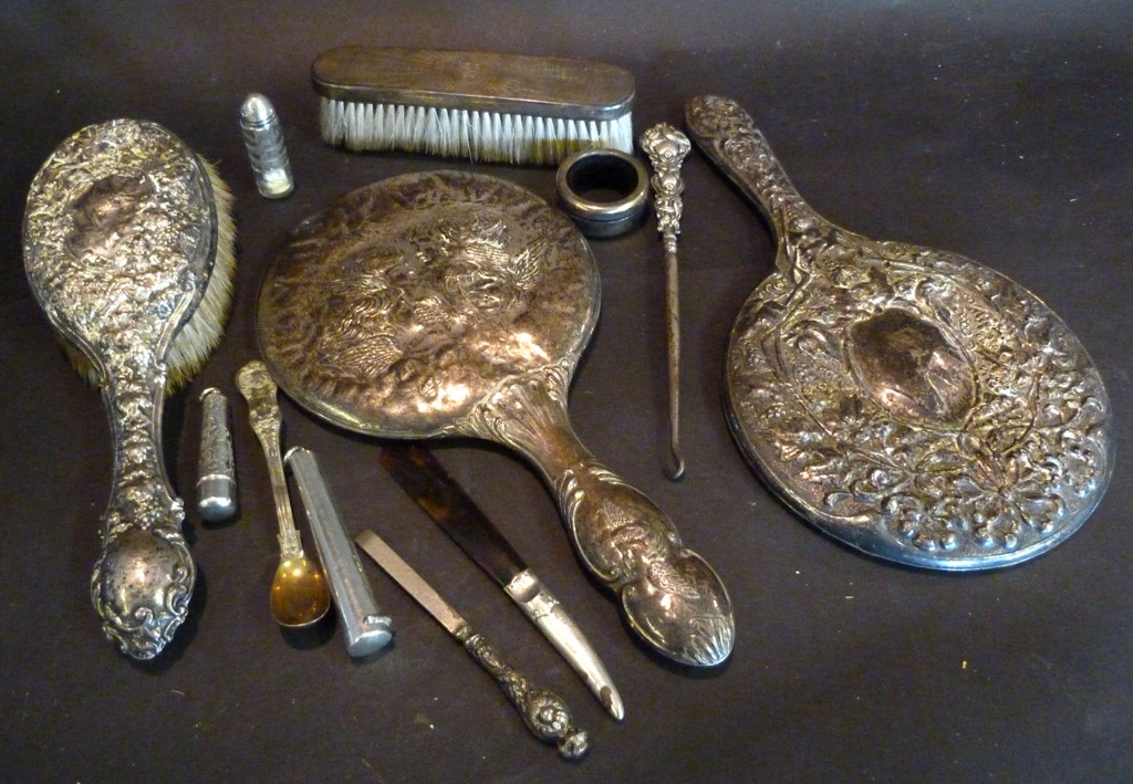A Silver Backed Hand Mirror, together with another similar silver backed hand mirror decorated