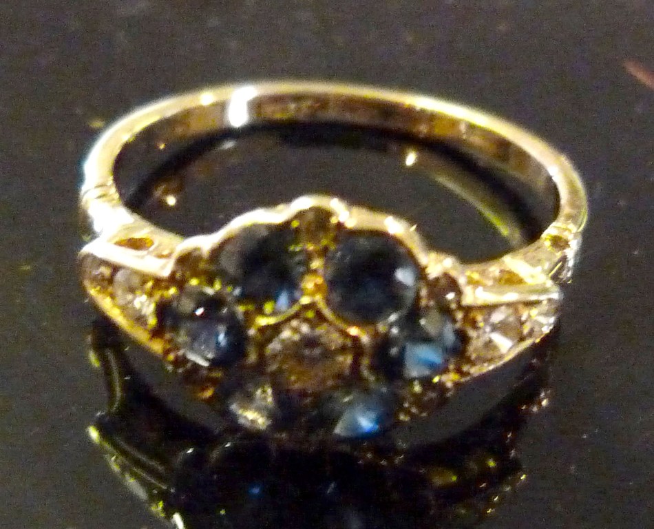 An 18ct.Yellow Gold Sapphire and Diamond Ring, set with a central diamond surrounded by six