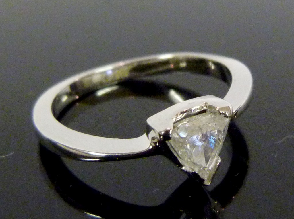 A 14ct.White Gold Solitaire Diamond Ring, the pear cut stone claw set and with diamond shoulders,