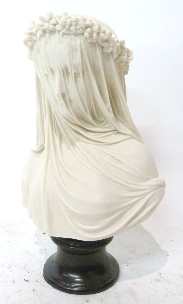 A White Marble Bust, a veiled bride, upon circular slate socle, 33cms high