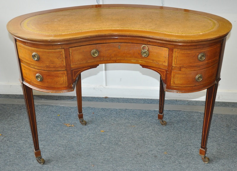 AN EDWARDIAN MAHOGANY KIDNEY SHAPED WRITING DESK with inset leather top, five drawers with