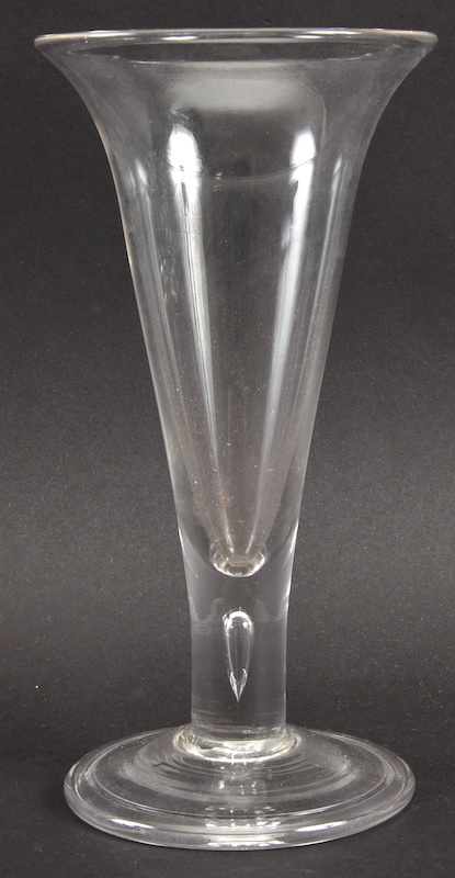 A PLAIN GEORGIAN FLUTED WINE GLASS with teardrop stem and circular base. 8ins high.