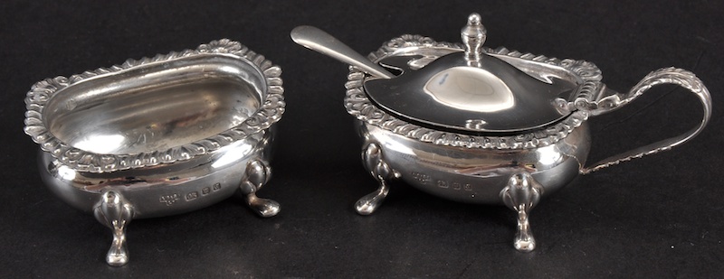 A MUSTARD POT AND SALT CELLAR with gadrooned edge.