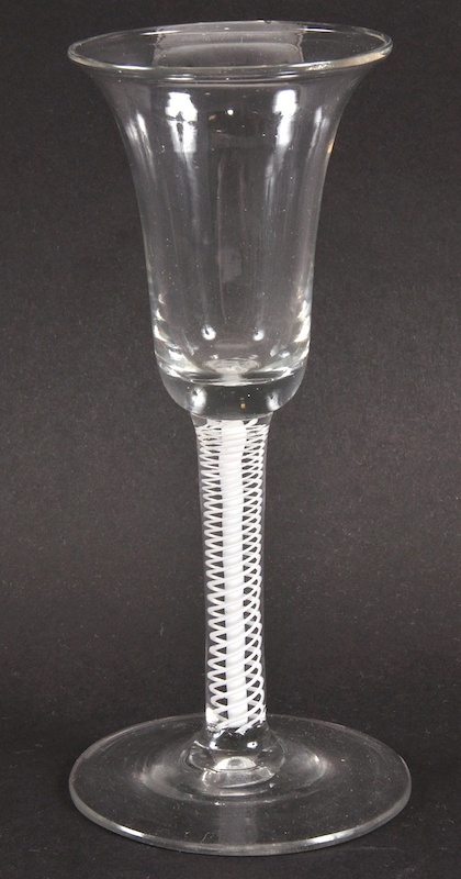 A GEORGIAN WINE GLASS with inverted bell shaped bowl and white opaque air twist stem. 6.25ins high.