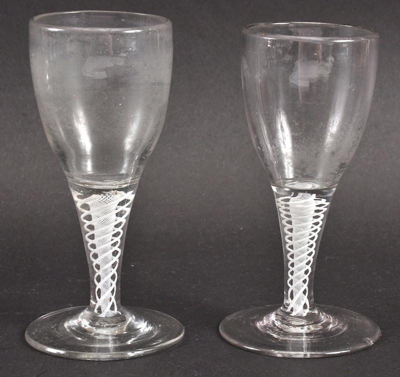 A PAIR OF GEORGIAN WINE GLASSES with plain bowls and white opaque twist stems. 4.75ins high. One