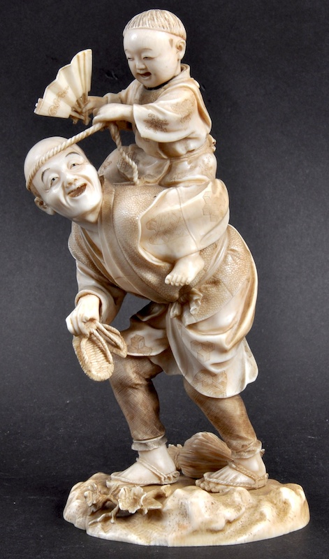 A 19TH CENTURY JAPANESE MEIJI PERIOD IVORY OKIMONO depicting a male in a shagreen jacket holding