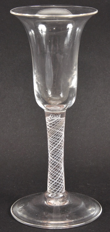 A GEORGIAN WINE GLASS with inverted bell shaped bowl and white opaque air twist stem. 6ins high.