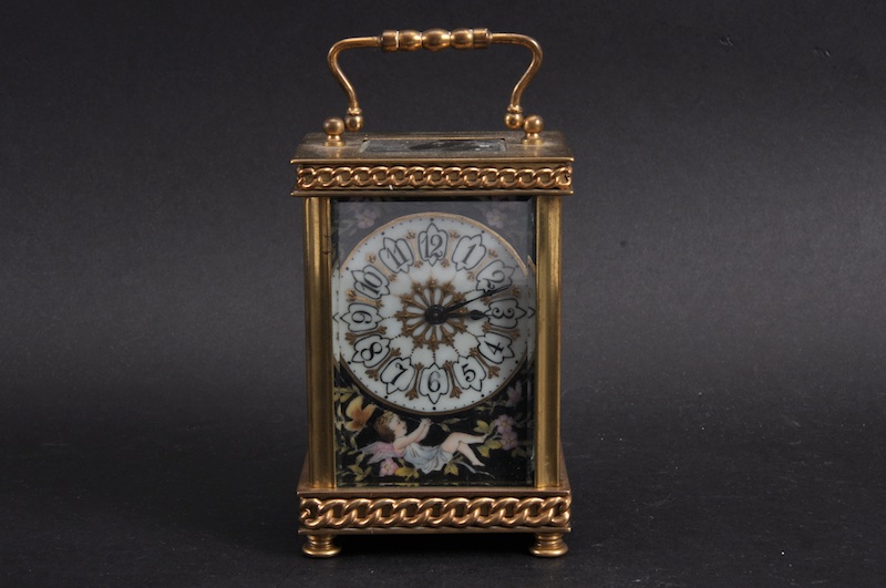 A FRENCH BRASS AND PORCELAIN CARRIAGE CLOCK with painted porcelain panels. 4½ins high.