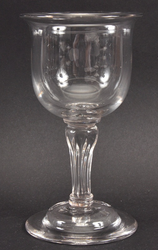 A PLAIN HEAVY GEORGIAN GOBLET with fluted stem and double raise base. 7ins high.
