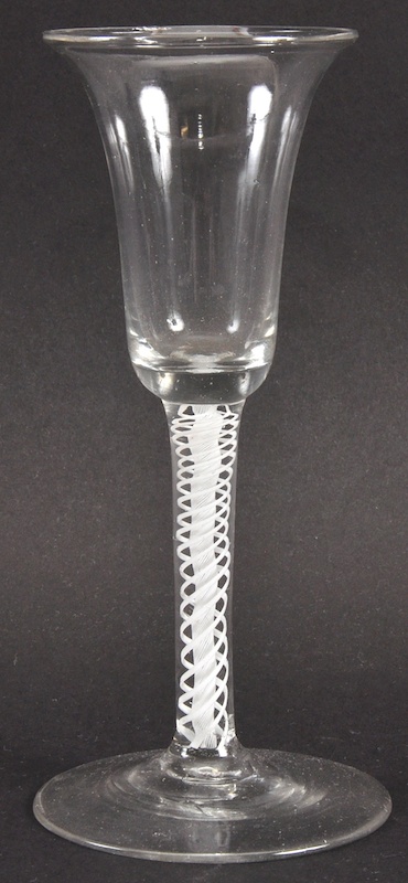 A GEORGIAN WINE GLASS with inverted bell shaped bowl and white opaque air twist stem. 6.25ins high.