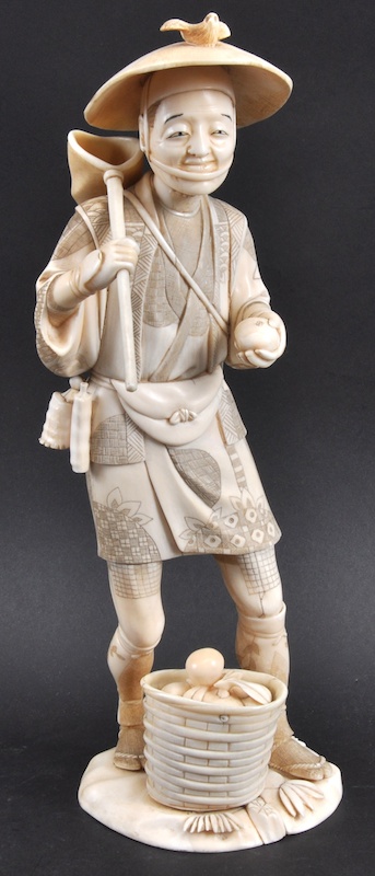 AN EARLY 20TH CENTURY JAPANESE MEIJI PERIOD IVORY OKIMONO depicting a standing male harvesting