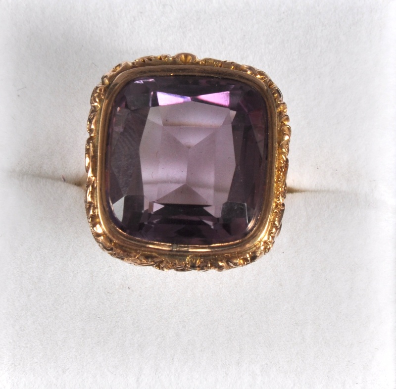 A LARGE AMETHYST GOLD SET RING.