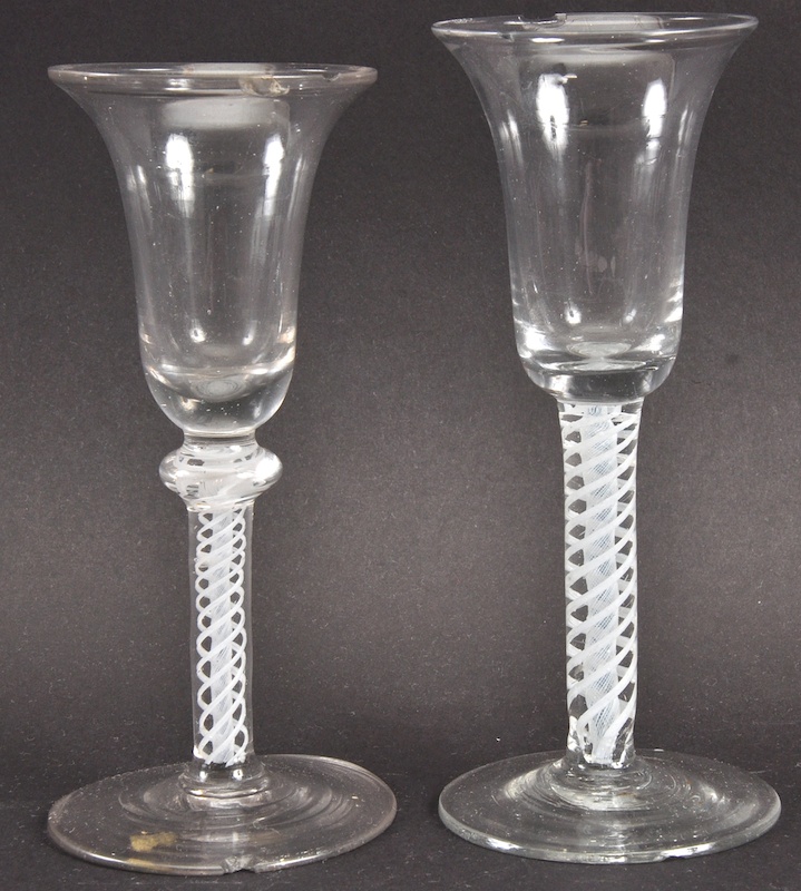 TWO GEORGIAN WINE GLASSES with inverted bell shaped bowls with white opaque stems. 6.5ins high. Both