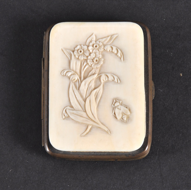 A SMALL IVORY PURSE WITH FLOWERS.