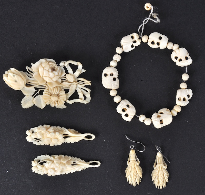 A SMALL BAG OF CARVED IVORY BROOCHES ETC.