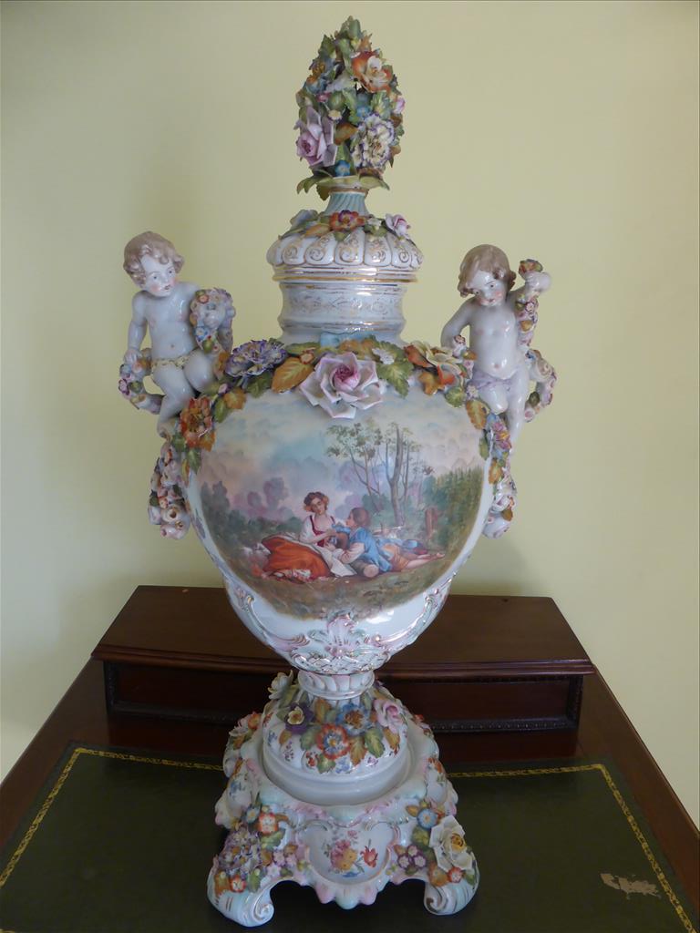 CONTINENTAL LIDDED VASE ON STAND ROCOCO STYLE WITH FLOWER ENCRUSTED DECORATION AND RAISED CHERUB
