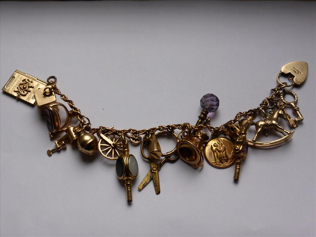 9CT GOLD CHARM BRACELET WITH 18, MOSTLY GOLD, CHARMS ON A FANCY BELCHER CHAIN LINK BRACELET WITH